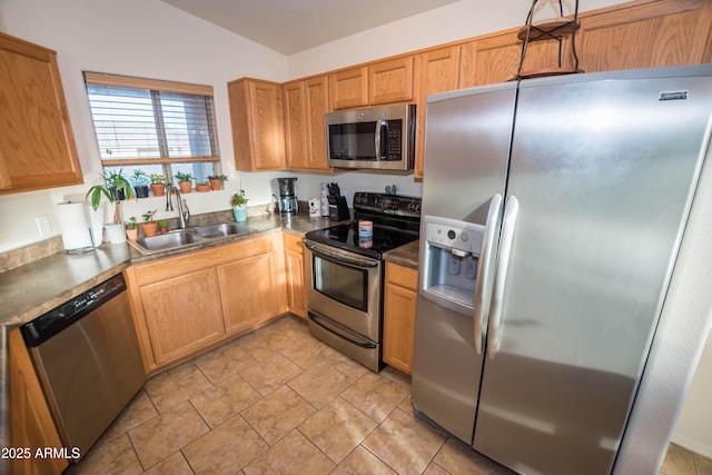 kitchen with lofted ceiling, sink, stainless steel appliances, and light tile patterned flooring