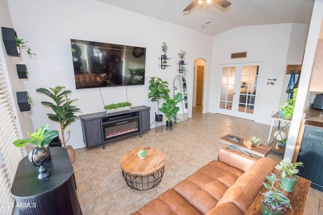 living room with lofted ceiling, ceiling fan, and french doors