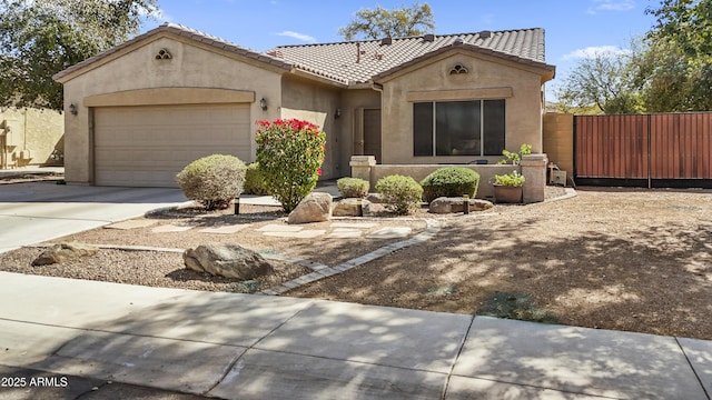 mediterranean / spanish-style house featuring a tile roof, stucco siding, an attached garage, fence, and driveway