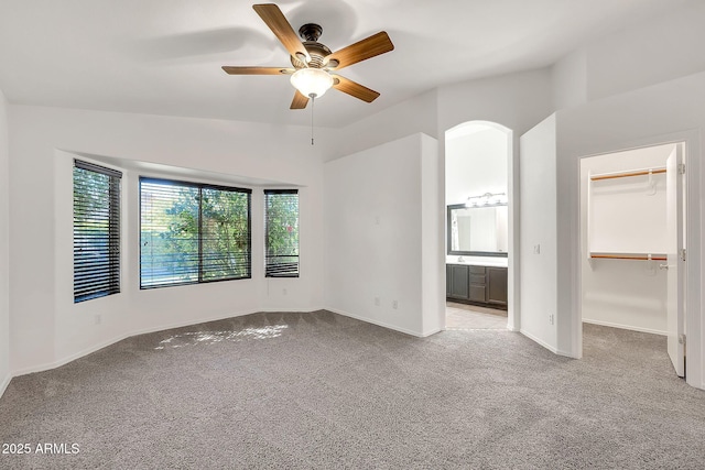 8009 W Salter Dr, Peoria, AZ 85382 - unfurnished bedroom featuring light colored carpet, a spacious closet, baseboards, ensuite bath, and a ceiling fan
