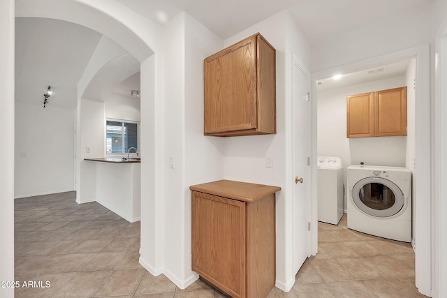 8009 W Salter Dr, Peoria, AZ 85382 - laundry area featuring light tile patterned floors, washing machine and clothes dryer, arched walkways, and baseboards