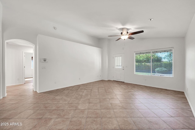 8009 W Salter Dr, Peoria, AZ 85382 - empty room featuring arched walkways, ceiling fan, light tile patterned flooring, lofted ceiling, and baseboards