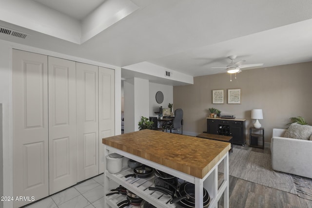 kitchen featuring ceiling fan, light hardwood / wood-style floors, and wood counters