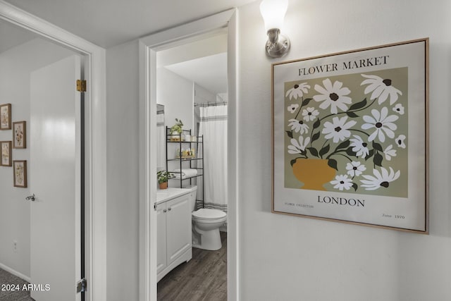 bathroom featuring hardwood / wood-style flooring, vanity, curtained shower, and toilet