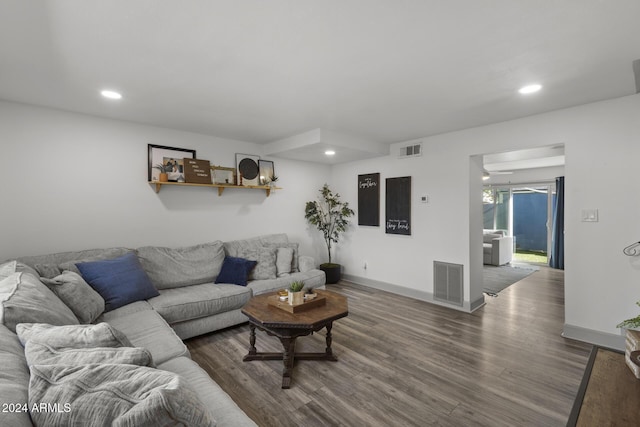 living room featuring ceiling fan and dark hardwood / wood-style flooring