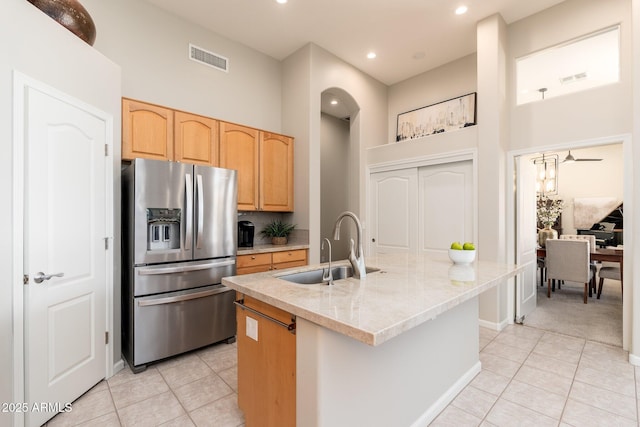 kitchen featuring light tile patterned floors, visible vents, stainless steel fridge, and a sink