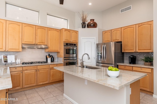 kitchen featuring backsplash, visible vents, appliances with stainless steel finishes, a sink, and under cabinet range hood