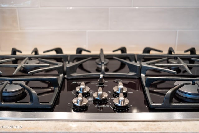 room details featuring decorative backsplash and stove