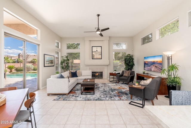 tiled living area with ceiling fan and a fireplace