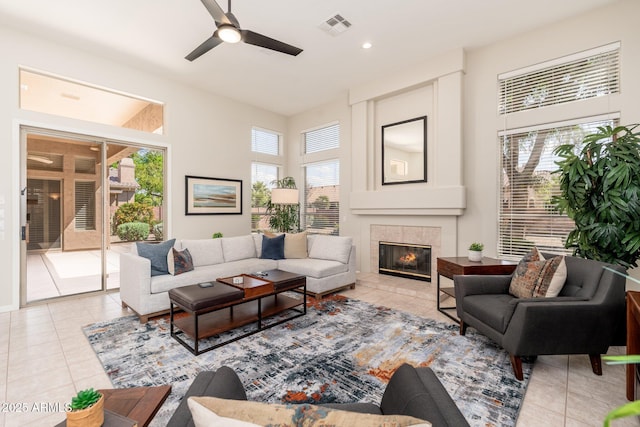 living room with visible vents, a ceiling fan, light tile patterned floors, and a tile fireplace