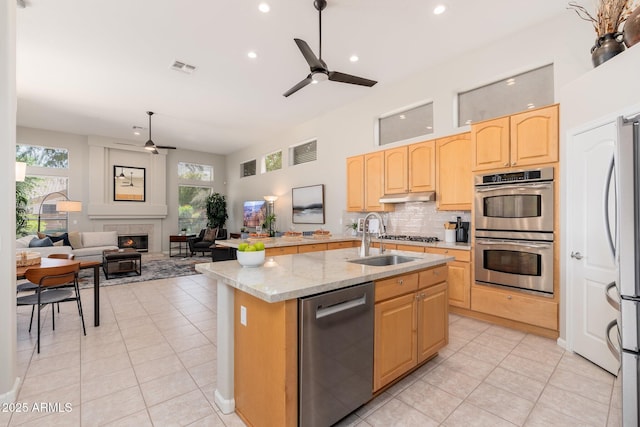 kitchen featuring light brown cabinetry, ceiling fan, appliances with stainless steel finishes, and a sink