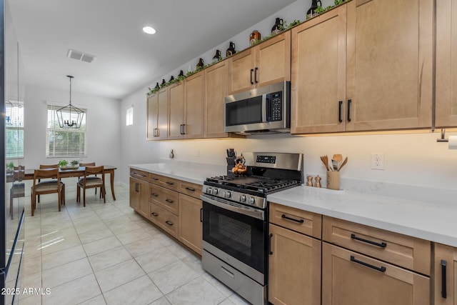 kitchen with visible vents, light tile patterned floors, a notable chandelier, light countertops, and appliances with stainless steel finishes