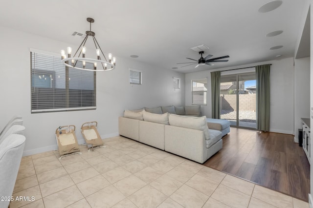 living room with visible vents, baseboards, and ceiling fan with notable chandelier