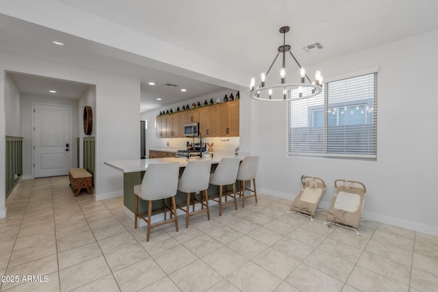 dining space with an inviting chandelier, baseboards, visible vents, and recessed lighting