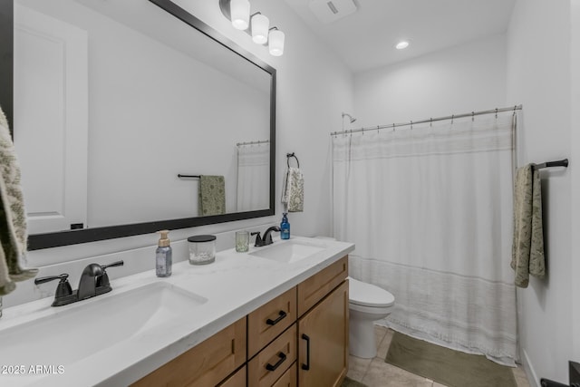 full bath featuring a sink, tile patterned floors, toilet, and double vanity