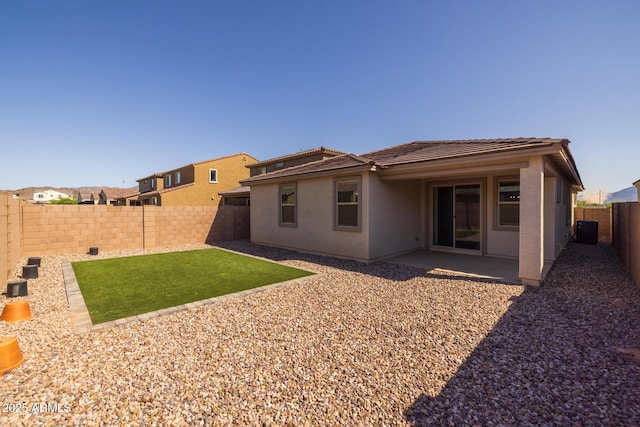 back of property with stucco siding, cooling unit, a patio area, a fenced backyard, and a tile roof