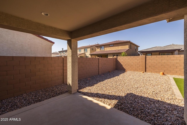 view of yard featuring a fenced backyard, a residential view, and a patio