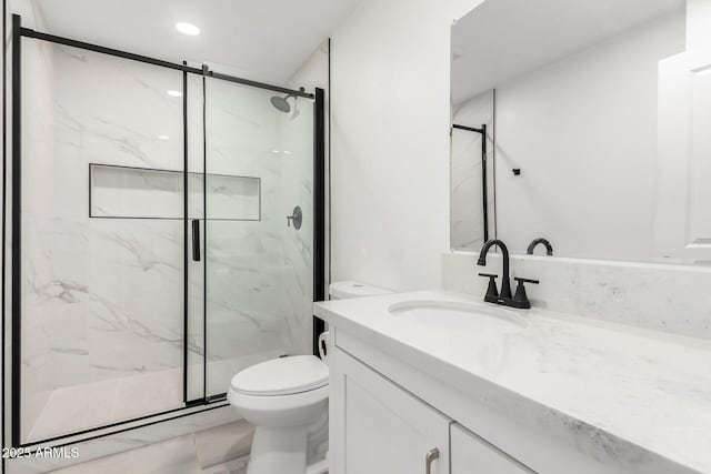 bathroom featuring a shower with door, toilet, and vanity