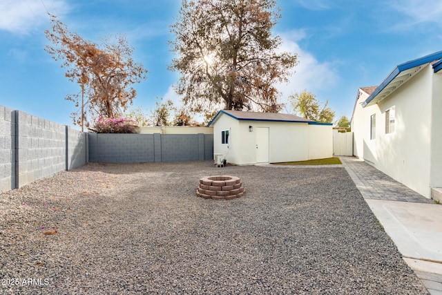 view of yard featuring an outdoor fire pit and an outdoor structure