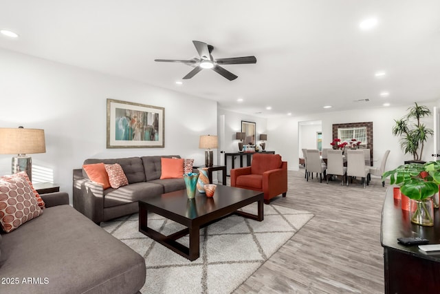 living room featuring ceiling fan and light hardwood / wood-style flooring