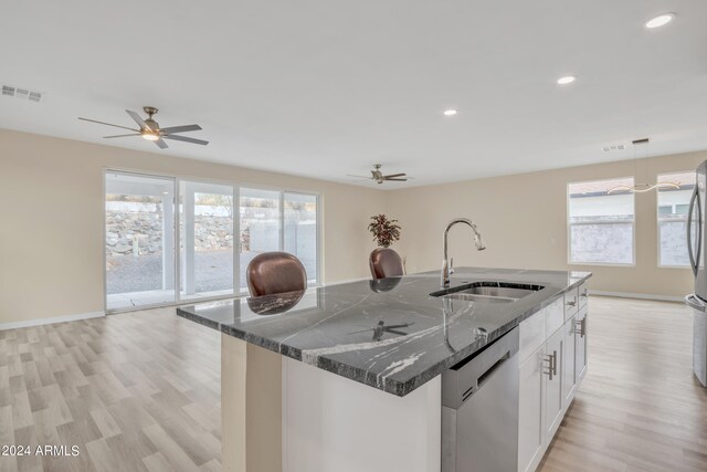 kitchen featuring dark stone countertops, stainless steel appliances, sink, white cabinetry, and ceiling fan