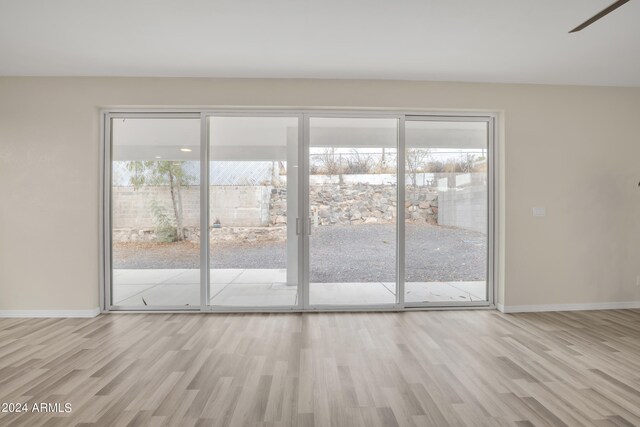 unfurnished room with light wood-type flooring and ceiling fan