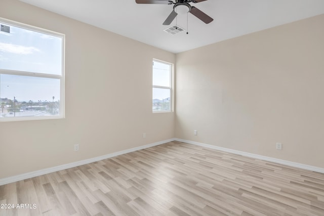 unfurnished room featuring light wood finished floors, visible vents, ceiling fan, and baseboards