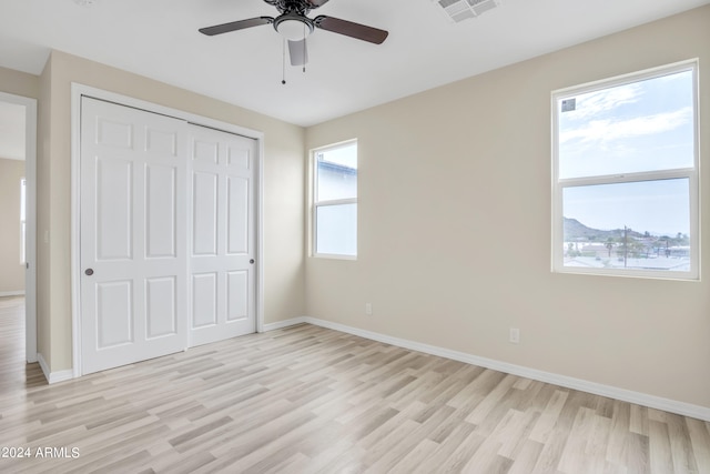 unfurnished bedroom with a closet, ceiling fan, and light hardwood / wood-style flooring