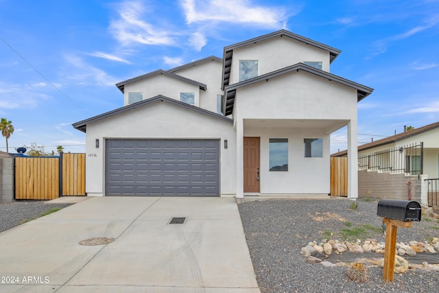 view of front of property featuring fence, driveway, and stucco siding