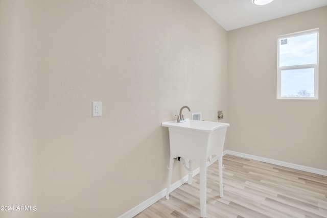 clothes washing area featuring hookup for a washing machine and light hardwood / wood-style floors