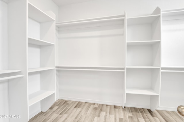 walk in closet with wood finished floors