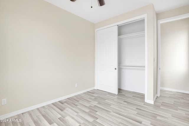 unfurnished bedroom featuring ceiling fan, a closet, and light wood-type flooring