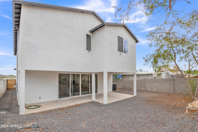 rear view of house featuring a patio area, a fenced backyard, and stucco siding