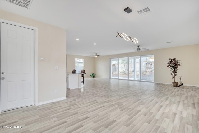 unfurnished living room featuring ceiling fan and light hardwood / wood-style floors