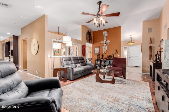 living room with ceiling fan, lofted ceiling, and light hardwood / wood-style flooring