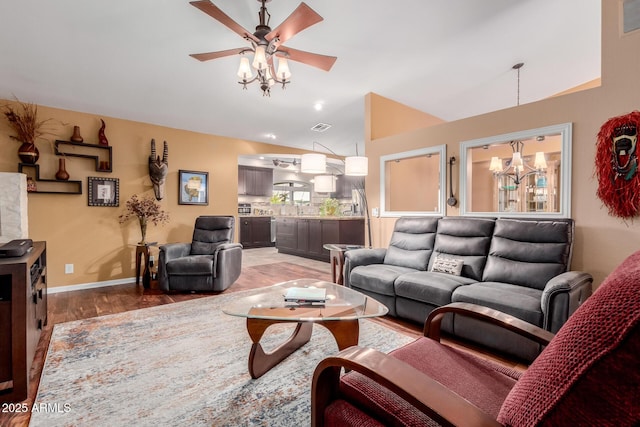 living room featuring ceiling fan with notable chandelier, sink, hardwood / wood-style floors, and vaulted ceiling