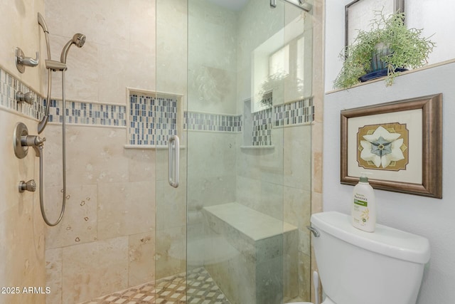 bathroom with a shower with shower door and toilet