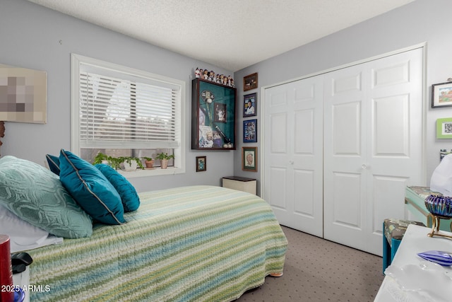 carpeted bedroom featuring a textured ceiling and a closet