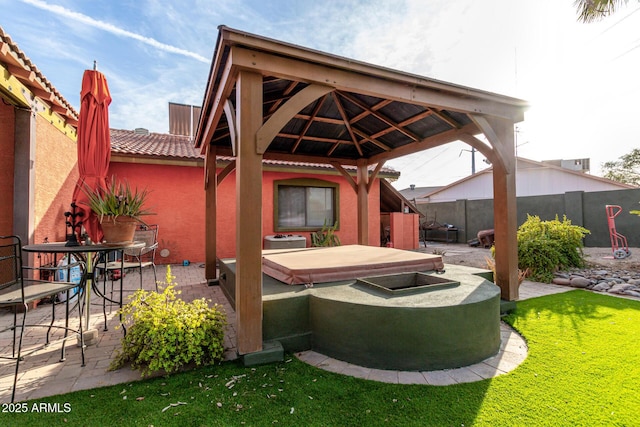 view of patio / terrace with a hot tub and a gazebo