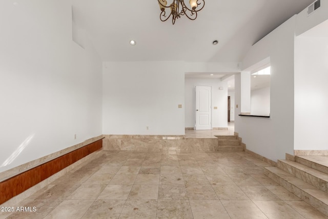 unfurnished room featuring lofted ceiling and a chandelier