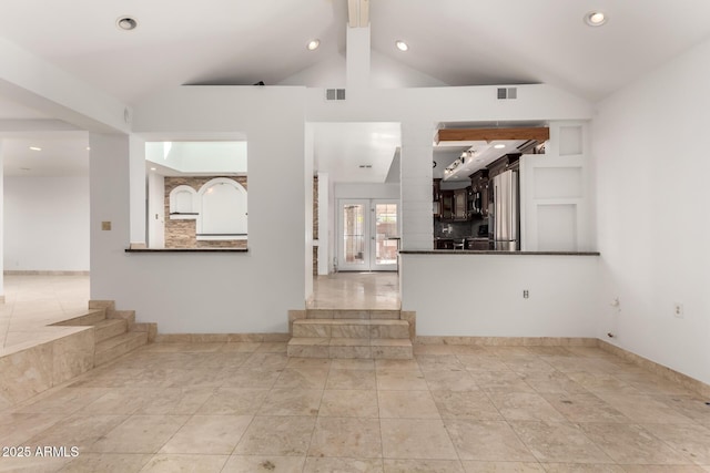 unfurnished living room with vaulted ceiling and french doors