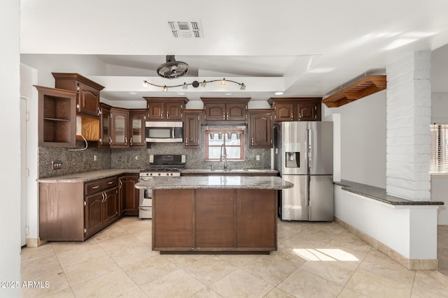 kitchen featuring dark brown cabinetry, sink, stainless steel appliances, and a kitchen island