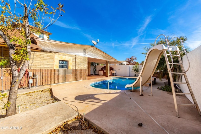 view of swimming pool with a patio area and a water slide