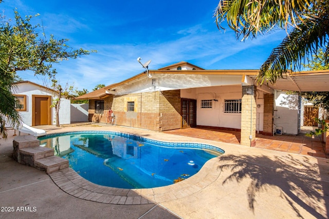 view of pool with a storage unit and a patio area