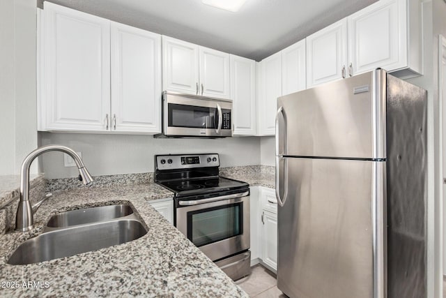 2301 E University Dr Unit 172, Mesa, AZ 85213 - kitchen with appliances with stainless steel finishes, a sink, white cabinets, light stone countertops, and light tile patterned floors