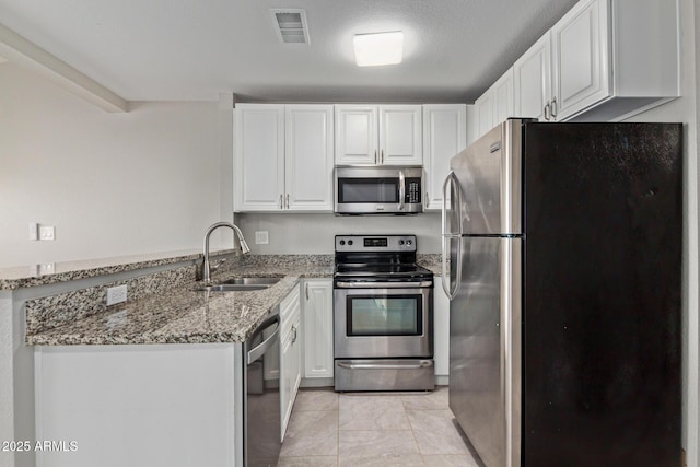 2301 E University Dr Unit 172, Mesa, AZ 85213 - kitchen with appliances with stainless steel finishes, a sink, a peninsula, light stone countertops, and white cabinetry