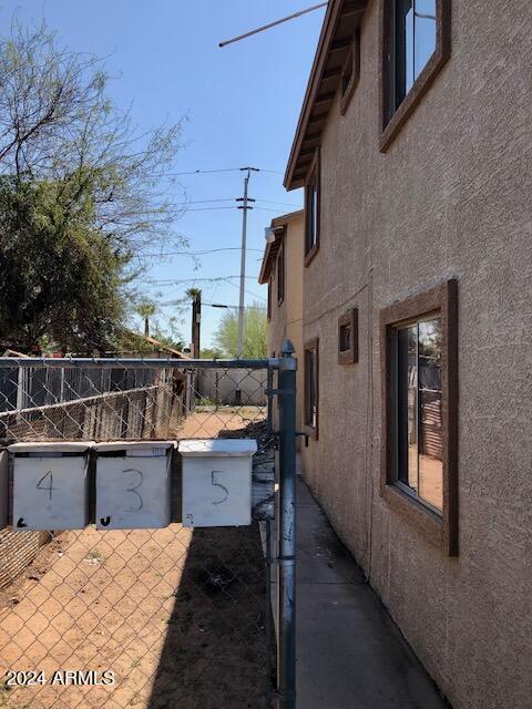 view of property exterior with fence and stucco siding