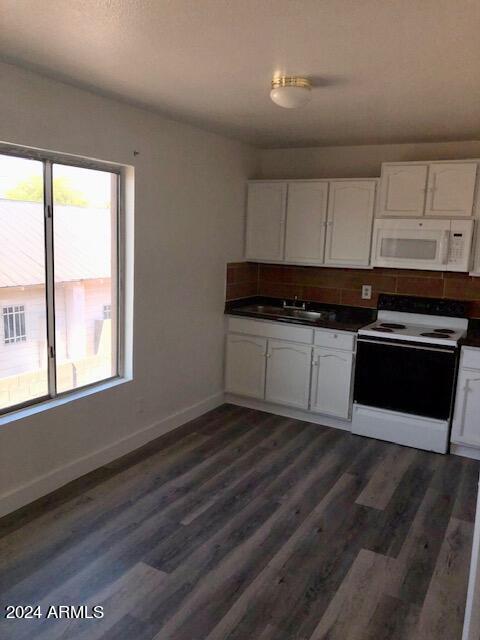 kitchen with white cabinets, white appliances, sink, and dark hardwood / wood-style flooring