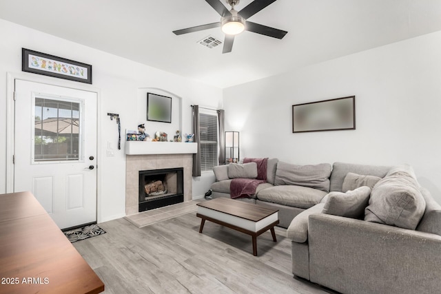 1961 N Hartford St Unit 1092, Chandler, AZ 85225 - living room featuring a ceiling fan, light wood-style flooring, and a tile fireplace