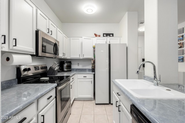 1961 N Hartford St Unit 1092, Chandler, AZ 85225 - kitchen featuring appliances with stainless steel finishes, white cabinets, light tile patterned floors, and light stone counters